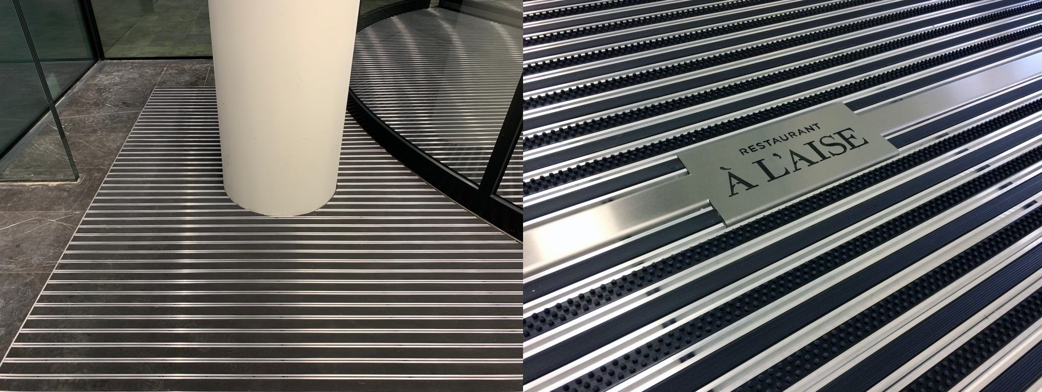 On this image, you can see a high-quality custom entrance mat, specifically designed for the demanding conditions of a heavily trafficked public building, effectively repelling both dirt and moisture.