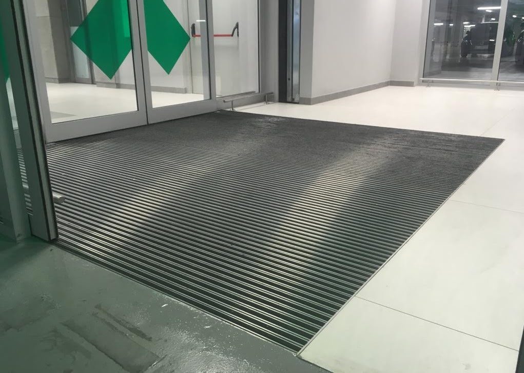 Das Innere des Gebäudes mit Eingangsmatten, die den Schmutz und die Feuchtigkeit von den Schuhsohlen festhalten.