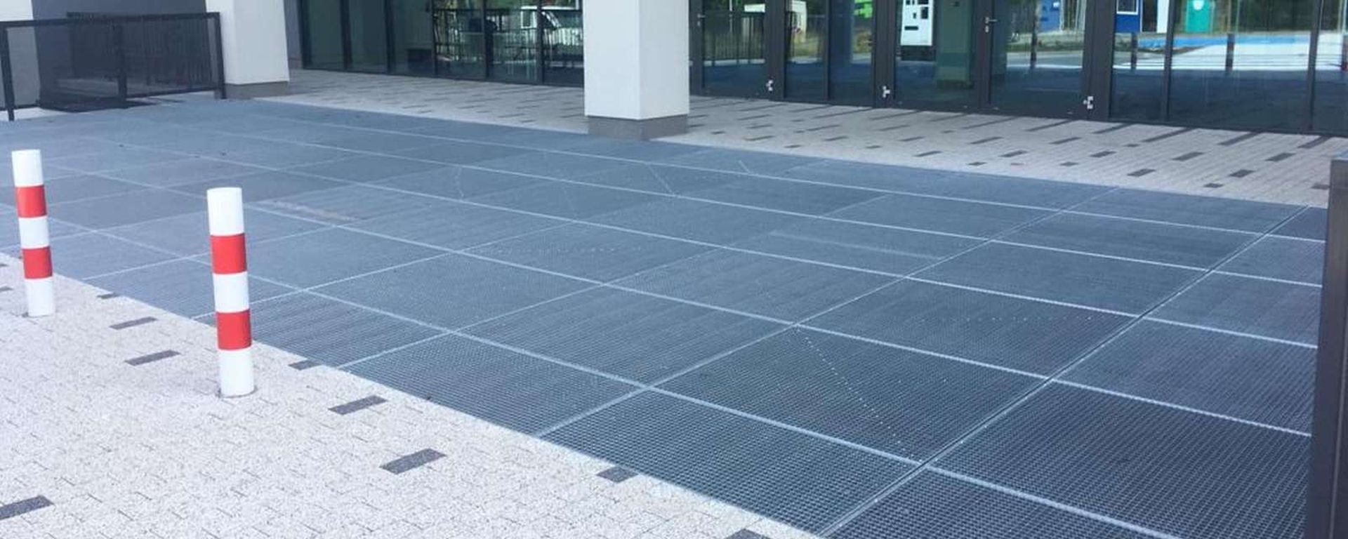 Gitterroste bilden eine große, vollständig komplette Eingangszone für das Gebäude.