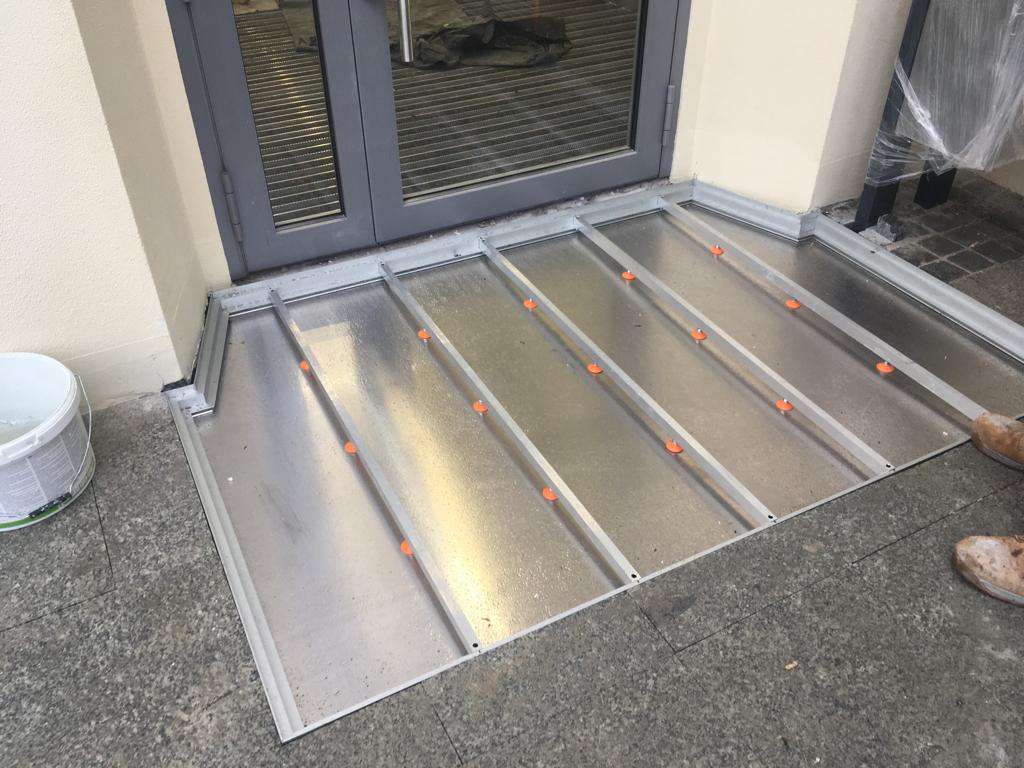Der Einbau einer Wanne zum Sammeln von Dreck von den Sohlen.
